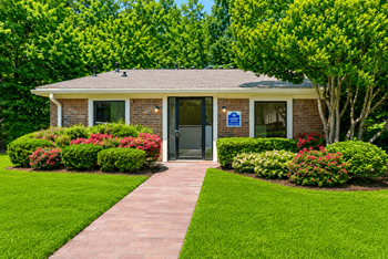 Leasing office with covered entrance and flowering shrubs
